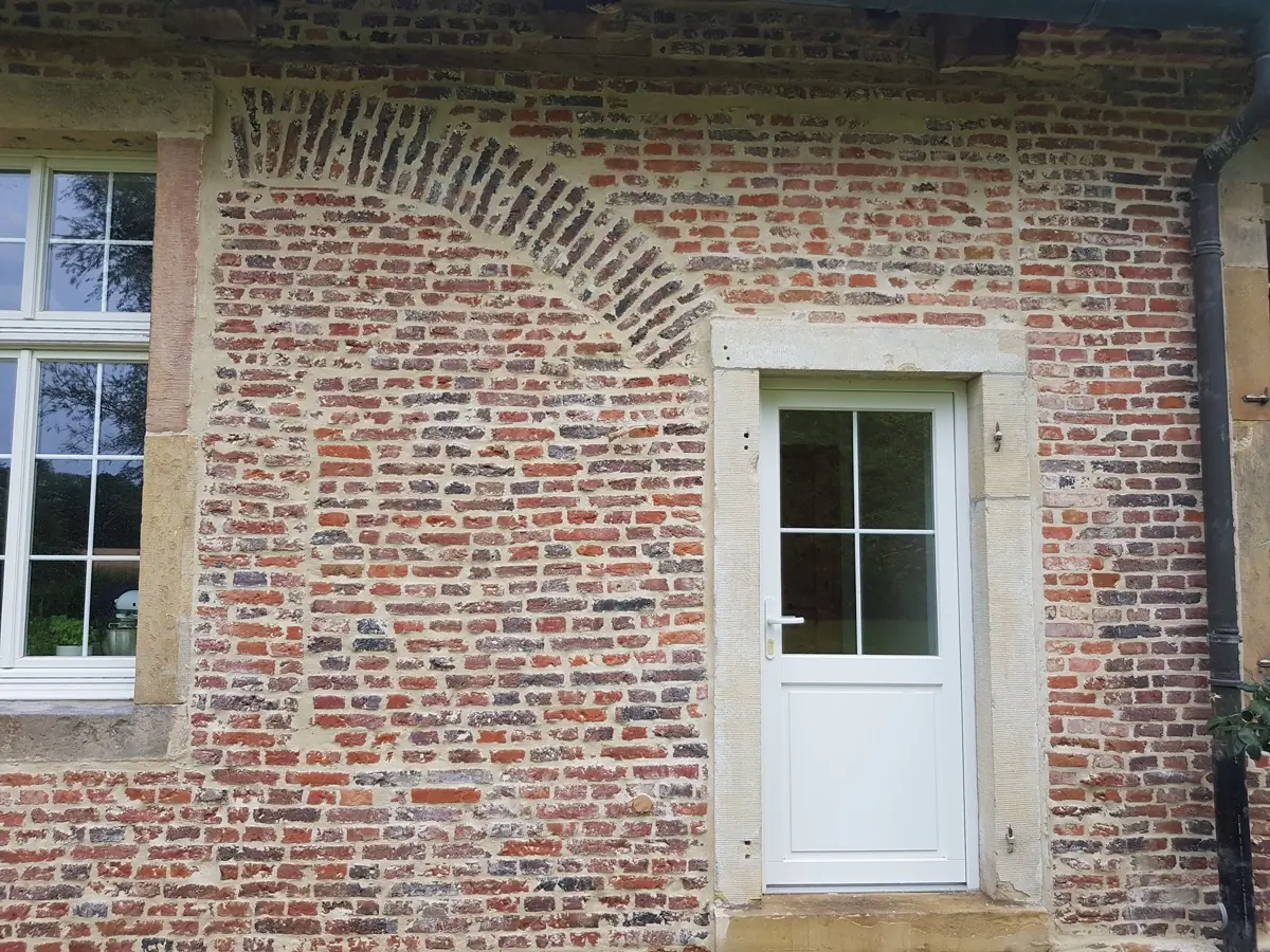 Restaurierte Klinkerfassade eines Altbaus mit gemauertem Bogen