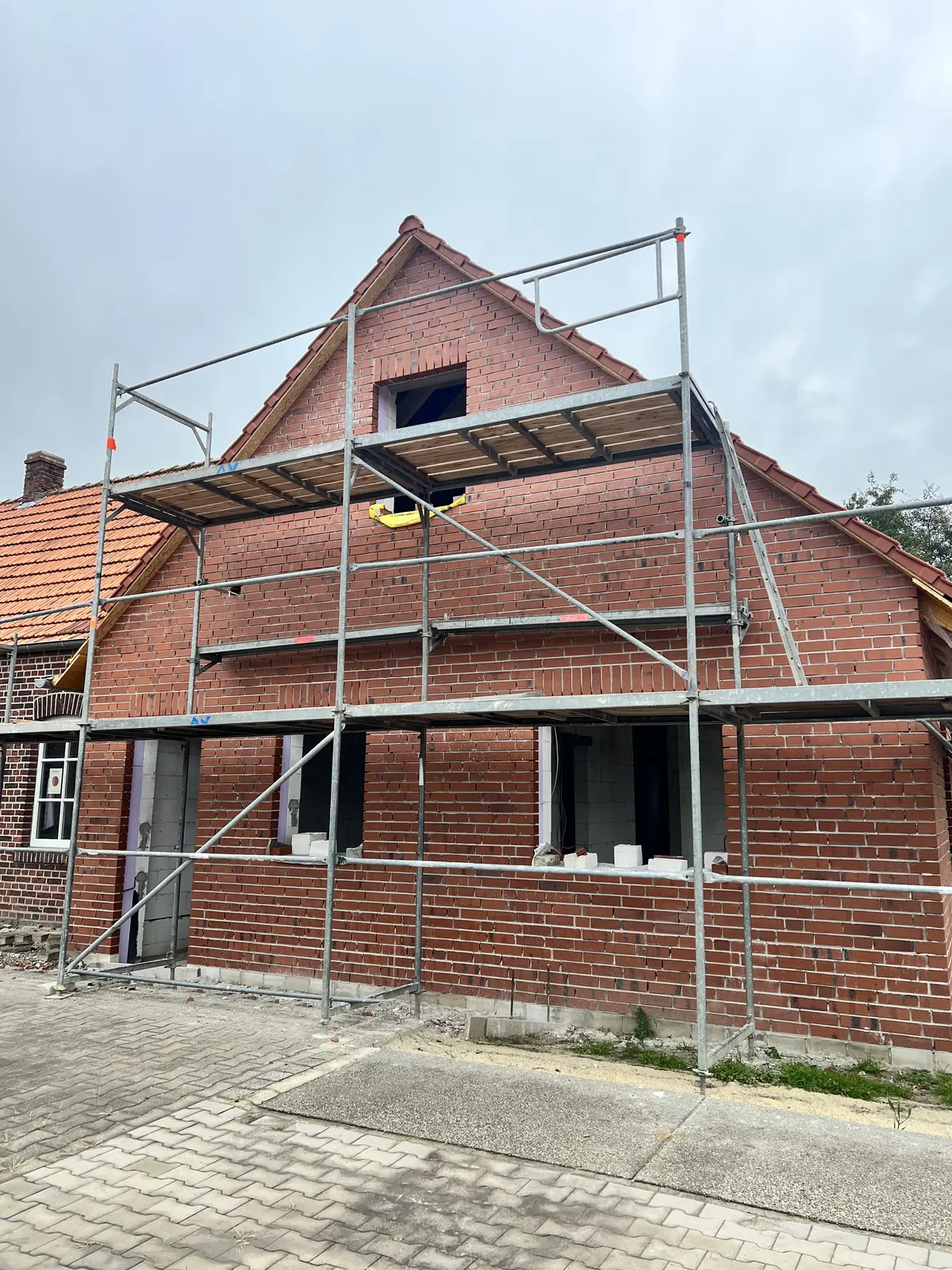 Neubau mit rotem Verblendmauerwerk in Münster-Wolbeck, eingerüstet für die Neuverfugung