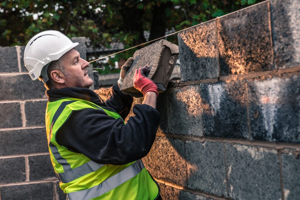 Workers laying bricks on construction site